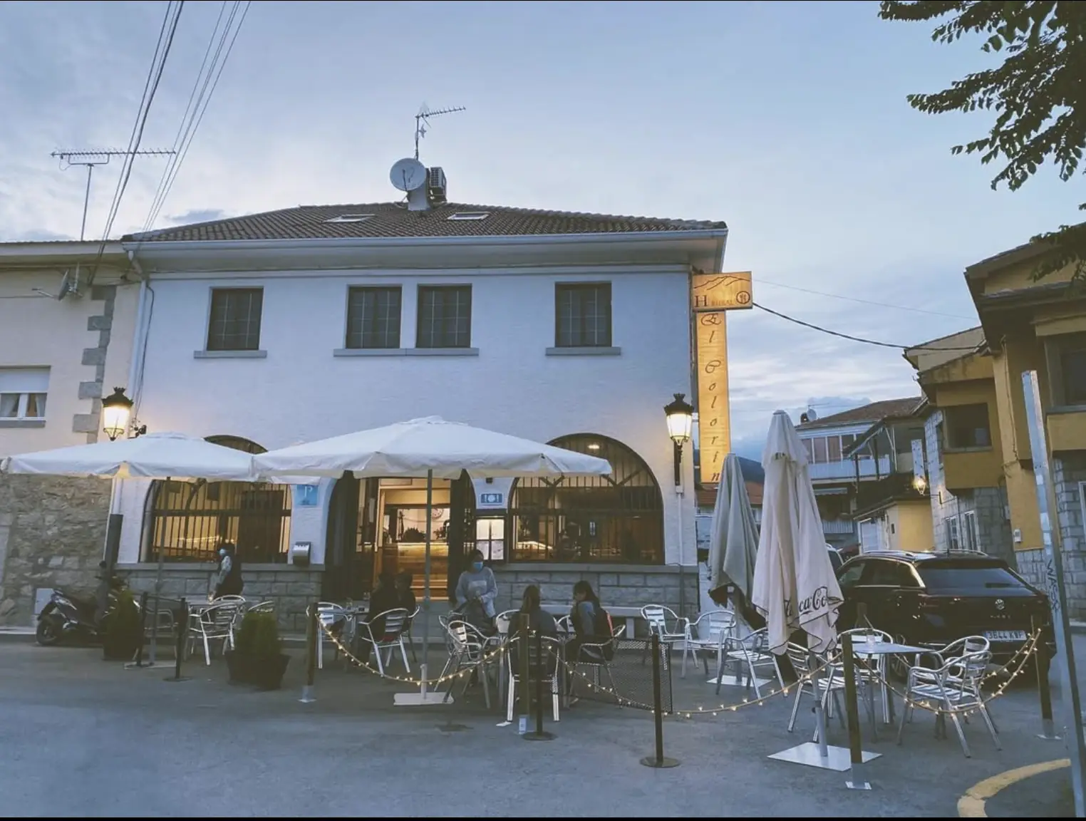 Fachada y terraza del Hostal Restaurante El Colorín, en Los Molinos, al atardecer