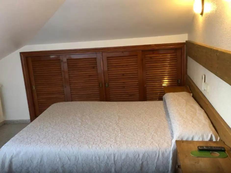 Habitación doble con cama de matrimonio y armario de madera