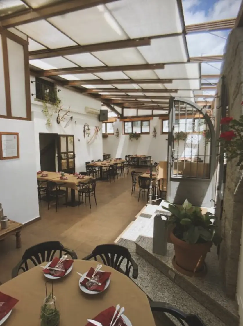 Comedor acristalado del restaurante con las mesas preparadas